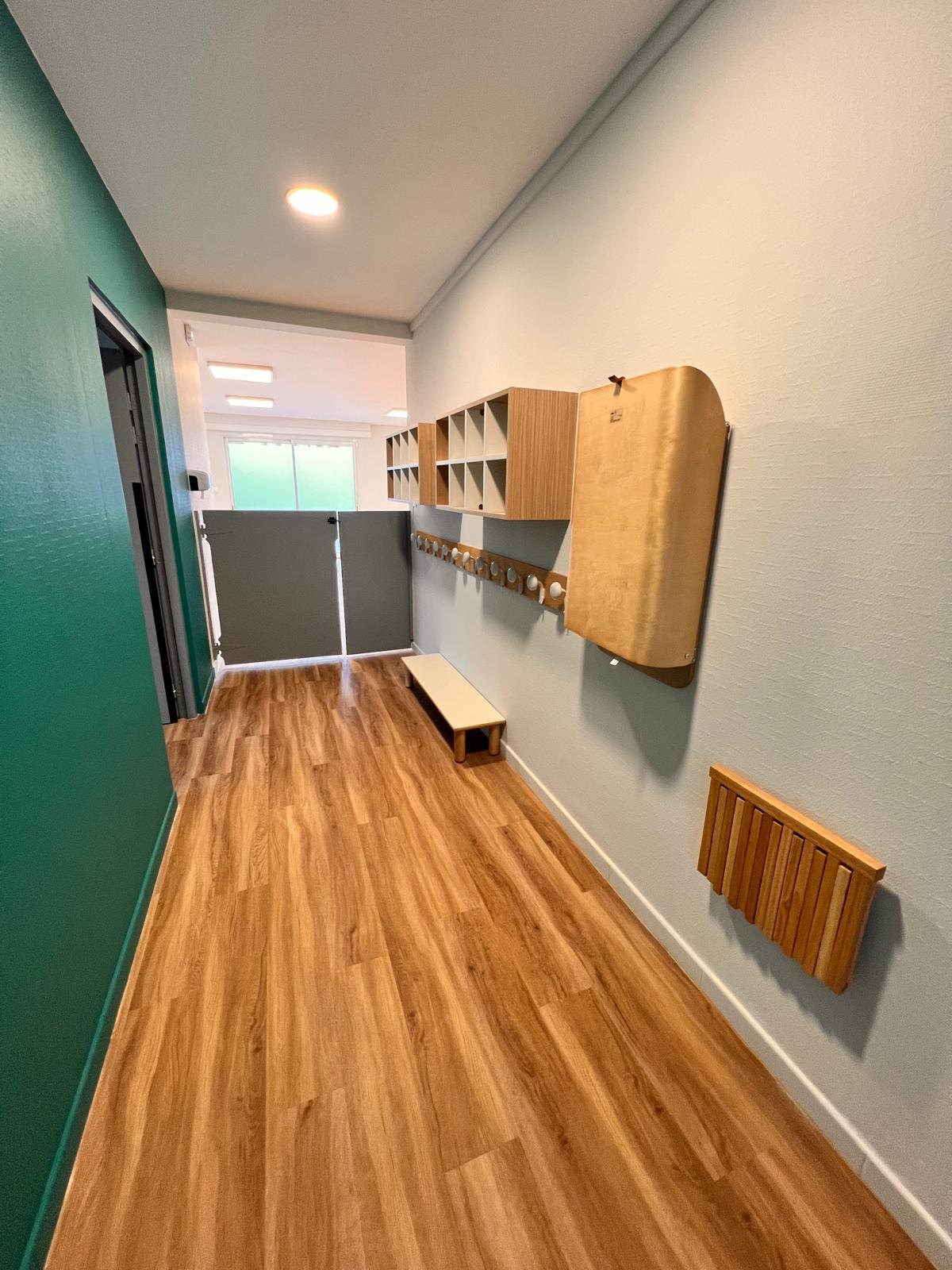 Couloir et espace soins de la micro-crèche Mélisse à Dachstein, table à langer repliée contre le mur pour libérer le passage